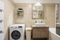 a bathroom with a washing machine and a sink at Apt 6P - Standing RER Tram Paris Orly Velizy in Le Plessis-Robinson