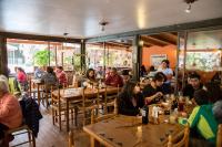 a group of people sitting at tables in a restaurant at Cabañas Refugio El Molle in El Molle