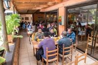 a group of people sitting at tables in a restaurant at Cabañas Refugio El Molle in El Molle
