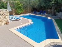 a swimming pool with two chairs and a table and a pool at Ta’ Peppi Farmhouse in Qala