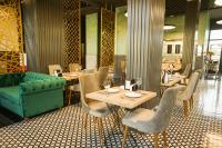 een restaurant met een groene bank en tafels en stoelen bij Aram Otel Business & Luxury in Istanbul