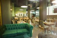 een groene bank in een restaurant met tafels en stoelen bij Aram Otel Business & Luxury in Istanbul