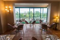 Un restaurante con mesas y sillas y un gran ventanal. en CÔTE GARONNE le BALCON DES DAMES -hôtel et restaurant- Tonneins Fauillet Marmande - vue panoramique bord de Garonne chambres climatisées, en Tonneins