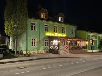 a green building with a neon sign on a street at Hotel am Schloss - Frankfurt an der Oder in Frankfurt&#47;Oder
