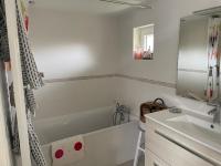 a white bathroom with a tub and a sink at Maison du bonheur in Saint-Mards-de-Fresne