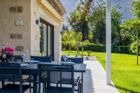 a patio with a table and chairs and a yard at SERRENDY Calm family house with swimming pool in Antibes