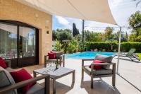 a patio with a table and chairs and a pool at SERRENDY Calm family house with swimming pool in Antibes