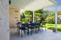 a patio with a table and chairs under a pergola at SERRENDY Calm family house with swimming pool in Antibes