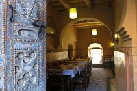 a dining room with tables and chairs in a building at Kasbah Hotel Ait Omar in Nkob