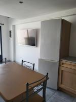 a kitchen with a wooden table and a refrigerator at Appart 30 m2 cosy 2 personnes 1 grande chambre en mezzanine in Saint-Mitre-les-Remparts