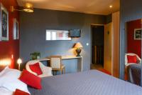 a hotel room with a bed with red pillows at Hotel La Chope in Cambrai