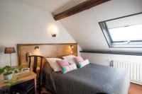 a bedroom with a bed and a desk and a window at Hotel La Chope in Cambrai