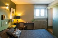 a bedroom with a bed and a desk with a computer at Hotel La Chope in Cambrai