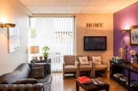 a living room with a couch and chairs and a tv at Hotel La Chope in Cambrai