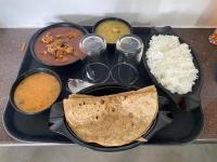 uma bandeja de alimentos com arroz e diferentes tipos de alimentos em Archana Resorts em Madikeri