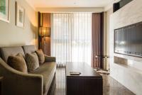 a living room with a couch and a television at Leofoo Residences in Taipei