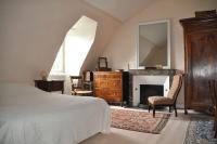 a bedroom with a bed and a fireplace and a mirror at La Valette, XVIIs House, Futuroscope in Saint-Léger