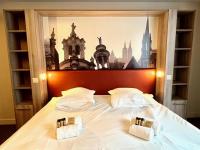 a bedroom with a large white bed with two pillows at Maïa YourHostHelper in Caen