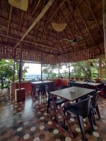 a restaurant with tables and chairs and a ceiling at Sunset Valley Kerala Pool Resort - Monsoon Forest Cottage Stay in Idukki with Private Waterfalls, Natural Streams & Breathtaking Views in Pīrmed