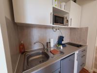 a small kitchen with a sink and a microwave at Studio Amazone 3 CLIM WIFI - Accès Port &amp; Centre-ville - ROSSIconciergerie - Linge en option in La Grande Motte