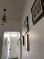 a hallway with three pictures on the wall and a door at Le Domaine : maison proche de la plage et du port in Fécamp