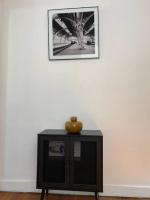 a table with a vase on top of it against a wall at Le Domaine : maison proche de la plage et du port in Fécamp