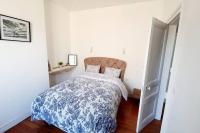 a bedroom with a bed with a blue and white comforter at Le Domaine : maison proche de la plage et du port in Fécamp