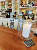 una vela en un frasco de cristal sobre una mesa en Hôtel Restaurant La Voile Bleue, en Erdeven