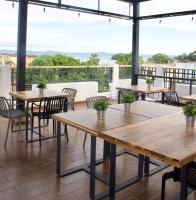 an outdoor patio with wooden tables and chairs at Hostal Marina Samana in Santa Bárbara de Samaná