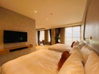 a hotel room with two beds and a flat screen tv at Cingjing Florence Resort Villa in Ren&#39;ai