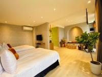 a bedroom with a large white bed and a tv at Cingjing Florence Resort Villa in Ren&#39;ai