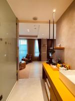 a kitchen with a yellow counter and a living room at Cingjing Florence Resort Villa in Ren&#39;ai