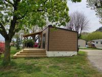 a tiny house with a porch and stairs at Camping le Rhône in Tournon-sur-Rhône