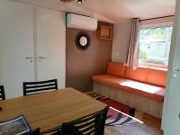 a living room with an orange couch and a table at Camping le Rhône in Tournon-sur-Rhône