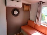 an orange couch in a room with a window at Camping le Rhône in Tournon-sur-Rhône