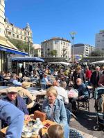 a group of people sitting at tables in a city at Appartement atypique et original in Nice