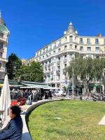 a woman sitting on a sidewalk in front of a building at Appartement atypique et original in Nice