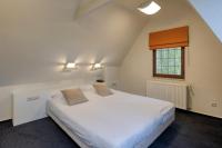 a bedroom with a large white bed and a window at Priorij Corsendonk in Oud-Turnhout