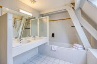 a bathroom with two sinks and a tub and a mirror at Priorij Corsendonk in Oud-Turnhout