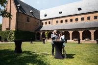 two people standing at a table in front of a building at Priorij Corsendonk in Oud-Turnhout