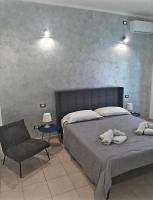 a bedroom with a bed and a chair and lights at La Nchioscia in La Spezia