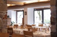 een eetkamer met witte tafels, stoelen en ramen bij Hotel Los Andes in Castello di Fiemme