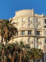 a large white building with palm trees in front of it at Paula by Terry&#39;s Homes in Cannes