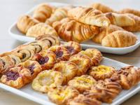 a bunch of pastries on plates on a table at JetPark Hotel Rotorua in Rotorua