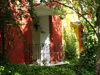 a red building with a gate in front of it at Ecotel Quinta Regia in Valladolid