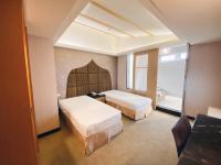 a bedroom with two beds and a window at JinShan Sakura Bay Hot Spring Hotel in Jinshan