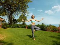 a woman in a bikini doing yoga in a yard at Taj Holiday Village Resort & Spa, Goa in Candolim