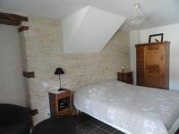 a bedroom with a bed and a wooden cabinet at Les chambres de Blanot in Blanot