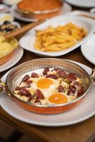 特拉布宗Montana Suite Bungalows的桌子上放着一口煎蛋锅，旁边还有炸薯条。