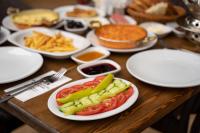 特拉布宗Montana Suite Bungalows的桌子上摆满了盛有蔬菜等食物的盘子。